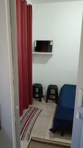 a room with a bed and a red curtain at Suites Aeroporto in Campinas