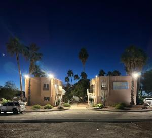 a house with palm trees in front of a parking lot at Flamingo Suites in Tucson