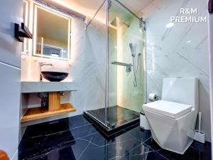 a bathroom with a glass shower and a toilet at R&M Premium in Baños +15 photos