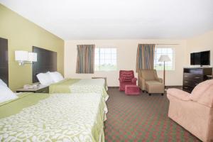 ein Hotelzimmer mit 2 Betten und einem Stuhl in der Unterkunft Days Inn by Wyndham Lexington NE in Lexington