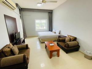 a living room with a bed and two couches at Cozy 1 Bedroom Hall in Khor Fakkan