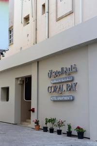 a sign on the side of a building with potted plants at Cozy 1 Bedroom Hall in Khor Fakkan +1 photo