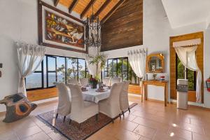 a dining room with a table and chairs and windows at Villa ines-4X4only-Jarabacoa-View-Jacuzzi-5BR in Jarabacoa