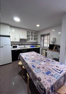a kitchen with a table with a tablecloth on it at Albergue Mar del Plata in Fisterra