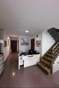 a living room with a desk and a staircase at Albergue Mar del Plata in Fisterra