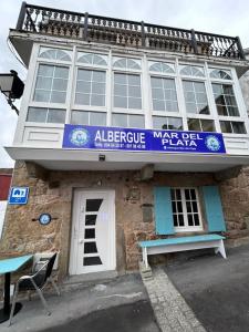 a building with a sign on the front of it at Albergue Mar del Plata in Fisterra