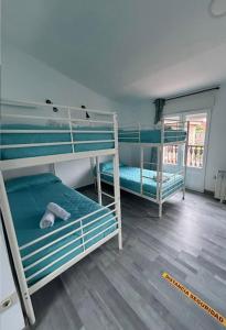 a room with three bunk beds in a room at Albergue Mar del Plata in Fisterra