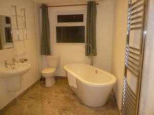 a bathroom with a tub and a toilet and a sink at Parrett Hotel in South Perrott