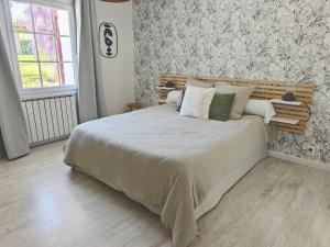 a bedroom with a large bed with a wooden headboard at Maison d'hôtes - La Forge de Clermont in Clermont