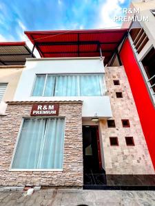 a red and white building with a red sign on it at R&M Premium in Baños