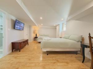 a bedroom with two beds and a tv on the wall at Cozy Rooms in Bright Walkout Suite - Newly Renovated in 2026 in Richmond Hill +29 photos