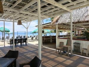 a restaurant on the beach with tables and chairs at Las Palmas Beach Roatan in Dixon Cove