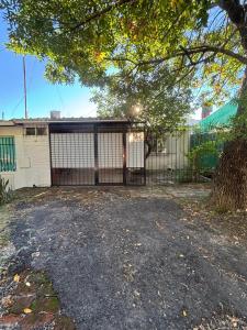 a house with a gate and a tree at Ciza - Departamento Temporario en Paraná in Paraná