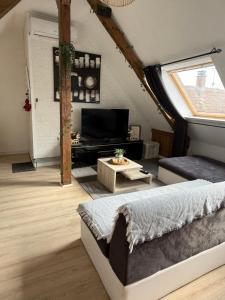 a room with a bed and a living room with a window at L'Alcôve Alsacienne chaleureux avec climatisation in Entzheim