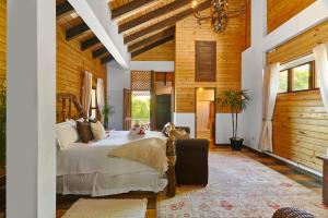 a bedroom with a large bed in a room with wooden walls at Villa ines-4X4only-Jarabacoa-View-Jacuzzi-5BR in Jarabacoa