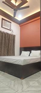 a bed in a room with a ceiling fan at kanakdhara aashraya in Vrindāvan +67 photos