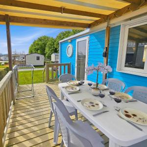 a white table and chairs on a deck at Mobilhome in Litteau