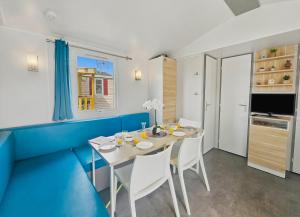 a dining room with a white table and chairs at Mobilhome in Litteau