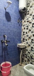 a bathroom with a toilet and a sink and a bucket at kanakdhara aashraya in Vrindāvan