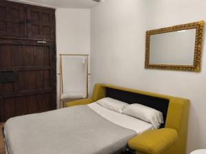 a bedroom with a bed and a mirror and a chair at El Patio del Convento in Toledo