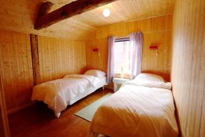 three beds in a room with a window at Cottage from 1850 in Ballstad in Ballstad