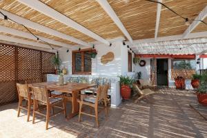 an outdoor patio with a wooden table and chairs at Skyloft - Rooftop Jacuzzi & Sea View - Central Kos in Kos