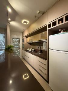 a kitchen with a white refrigerator and a sink at JUPET Studio in Brasília