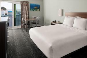 a hotel room with a large bed and a desk at Sand Dollar Inn in Seaside +19 photos