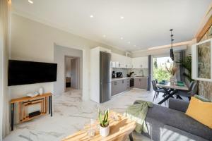 a living room with a couch and a tv at Villa Renata in Kontokali +21 photos