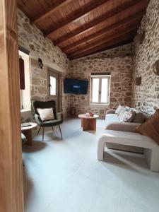 a living room with two couches and a tv at ARETOUSA Private Village Suite in Sitia