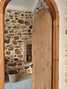 a wooden door in a room with a stone wall at ARETOUSA Private Village Suite in Sitia +67 photos