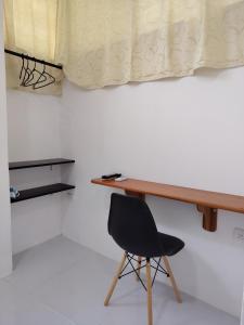 a desk with a black chair in a room at Galápagos Finch Apartment in Puerto Ayora
