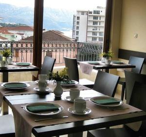 a table with chairs and a view of a balcony at Lucic Rooms & Suites in Budva