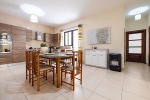 a kitchen with a table and chairs in a room at Mandalay Cozy & Affordable Apartment with Patio in Mellieħa