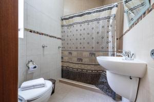 a bathroom with a sink and a toilet and a shower at Mandalay Cozy & Affordable Apartment with Patio in Mellieħa +20 photos