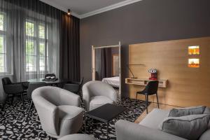 a hotel room with chairs and a bed and a mirror at Le Méridien Vienna in Vienna