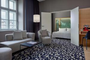 a hotel room with a bed and a couch and chair at Le Méridien Vienna in Vienna