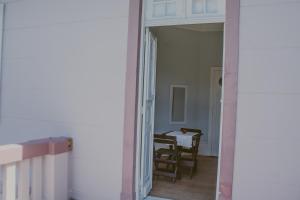 a hallway with a table and a chair in a room at Vila Santa Eulália Hostel in Pelotas