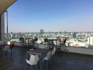 a restaurant with tables and chairs and a view of a city at Napoles Condo Suites in Mexico City