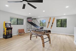 a living room with a table and a video game at Yosemite Outpost in Oakhurst