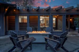 a patio with two chairs and a table with a fire pit at Yosemite Outpost in Oakhurst