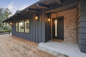 a house with a wooden porch and a brick building at Yosemite Outpost in Oakhurst +41 photos