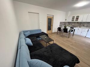 a living room with a blue couch and a kitchen at Apartman Caminito in Zadar +13 photos