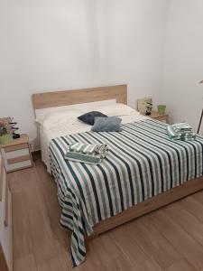 a bed with a black and white striped blanket at Casetta d'Ossuna in Palermo