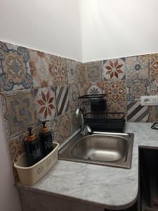 a kitchen counter with a stainless steel sink and tiles at Casetta d'Ossuna in Palermo +47 photos