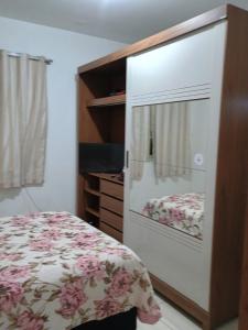 a bedroom with a bed and a dresser with a window at Casa da nicinha in Vitória