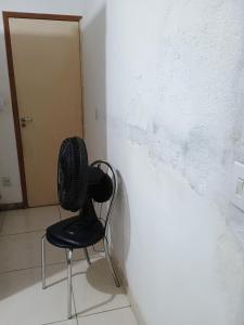a black chair sitting next to a white wall at Casa da nicinha in Vitória