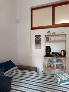 a bedroom with a bed with a blue and white striped blanket at Casetta d'Ossuna in Palermo