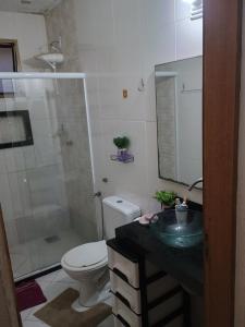 a bathroom with a toilet and a sink and a shower at Casa da nicinha in Vitória