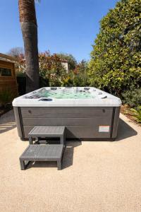 a hot tub and a bench next to a tree at Villa Clemarine - Piscine & Jacuzzi in Sanary-sur-Mer